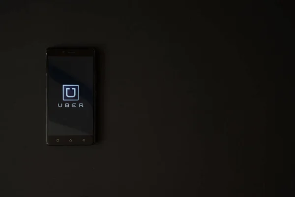 Logotipo Uber na tela do smartphone no fundo preto — Fotografia de Stock