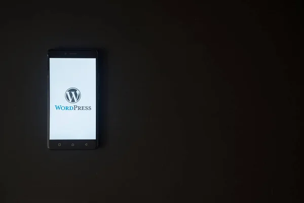 Wordpress logotipo na tela do smartphone no fundo preto — Fotografia de Stock