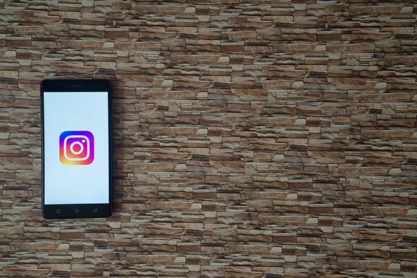 Logotipo do Instagram na tela do smartphone no fundo de pedra — Fotografia de Stock