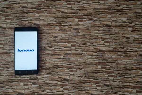 スマート フォンの画面背景に直面して石の上に Lenovo ロゴ — ストック写真