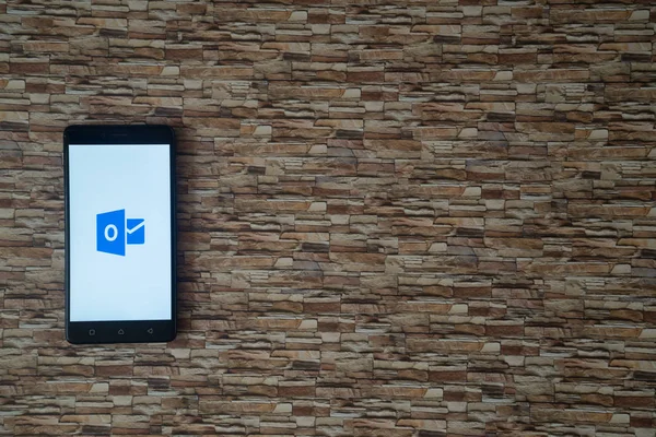 Logotipo de Microsoft Office Outlook en la pantalla del teléfono inteligente sobre fondo de piedra — Foto de Stock