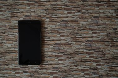 Arka plan karşı karşıya taş üstünde Smartphone perde