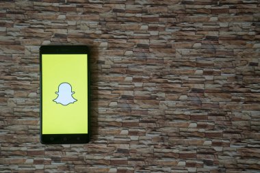 Snapchat logo üstünde smartphone perde arka plan karşı karşıya taş