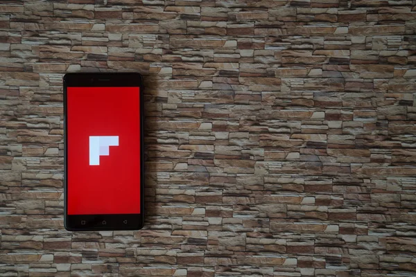 Logotipo de Flipboard en la pantalla del teléfono inteligente sobre fondo de piedra — Foto de Stock