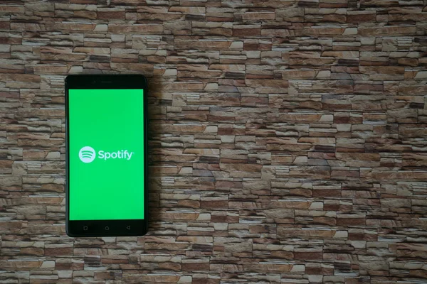 Spotify λογότυπο στην οθόνη του smartphone στην πέτρα που αντιμετωπίζει φόντο — Φωτογραφία Αρχείου