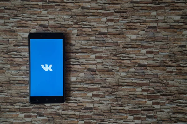 Logotipo de Vkontakte en la pantalla del teléfono inteligente sobre fondo de piedra — Foto de Stock