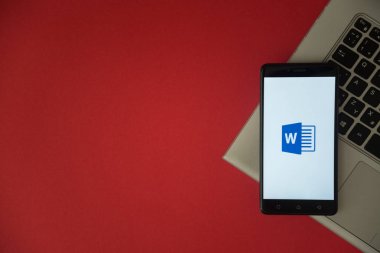 Microsoft office word logo üstünde laptop klavye üzerinde yerleştirilen smartphone perde. 
