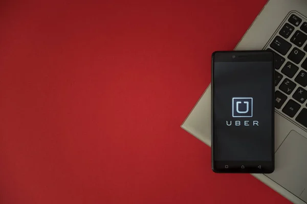 Logotipo de Uber en la pantalla del teléfono inteligente colocado en el teclado portátil . —  Fotos de Stock