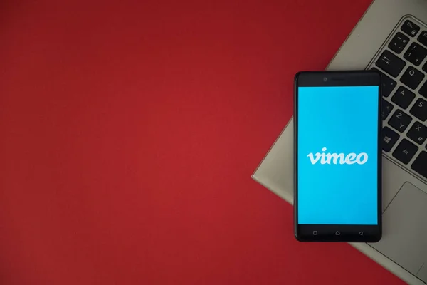 Logotipo de Vimeo en la pantalla del teléfono inteligente colocado en el teclado portátil . — Foto de Stock