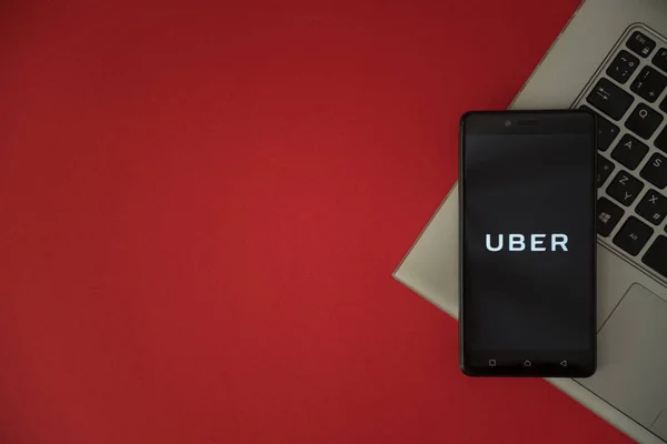 Logotipo Uber na tela do smartphone colocado no teclado do laptop . — Fotografia de Stock