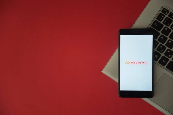 AliExpress logo na smartphone obrazovky na notebooku klávesnice. — Stock fotografie