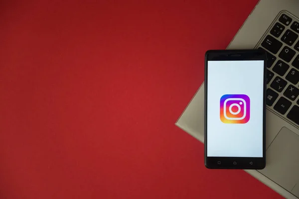 Instagram logo on smartphone screen placed on laptop keyboard. — Stock Photo, Image
