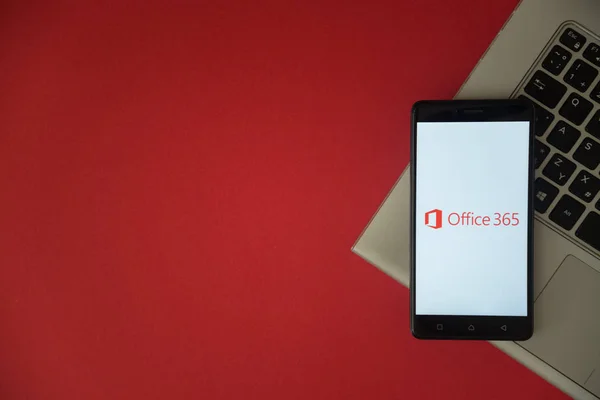 Microsoft Office 365 logotipo na tela do smartphone colocado no teclado do laptop . — Fotografia de Stock