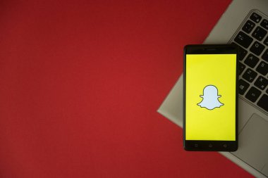 Snapchat logo üstünde laptop klavye üzerinde yerleştirilen smartphone perde. 
