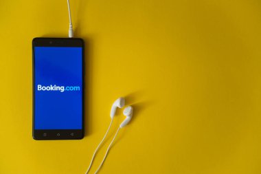 Booking.com logo üstünde smartphone perde Sarı zemin üzerine