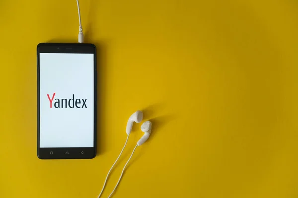 Yandex logo na ekranie smartfona na żółtym tle — Zdjęcie stockowe