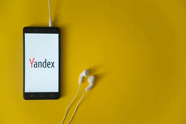 Logotipo Yandex na tela do smartphone no fundo amarelo — Fotografia de Stock