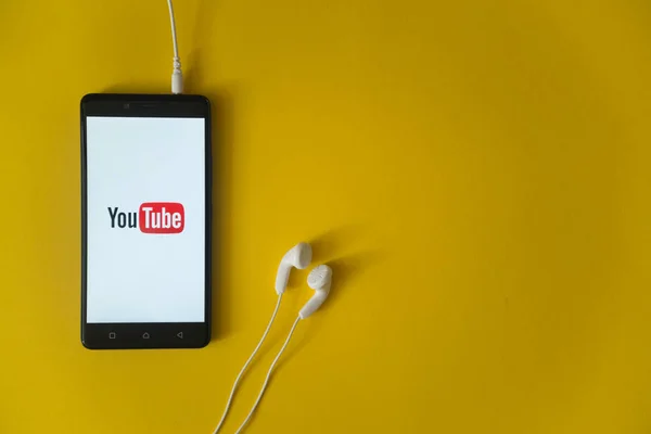 Logo YouTube na ekranie smartfona na żółtym tle — Zdjęcie stockowe