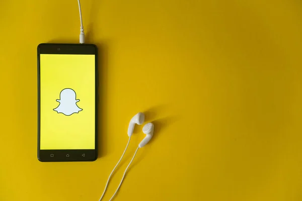 Snapchat logo üstünde smartphone perde Sarı zemin üzerine — Stok fotoğraf