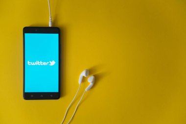 Logo üstünde smartphone perde sarı arka plan üzerinde twitter