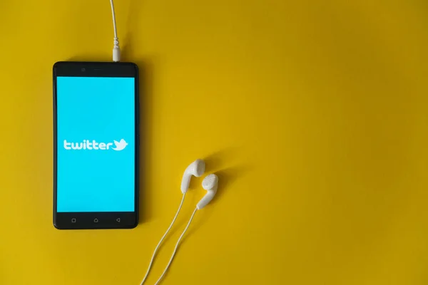 Logo de Twitter en la pantalla del smartphone sobre fondo amarillo — Foto de Stock