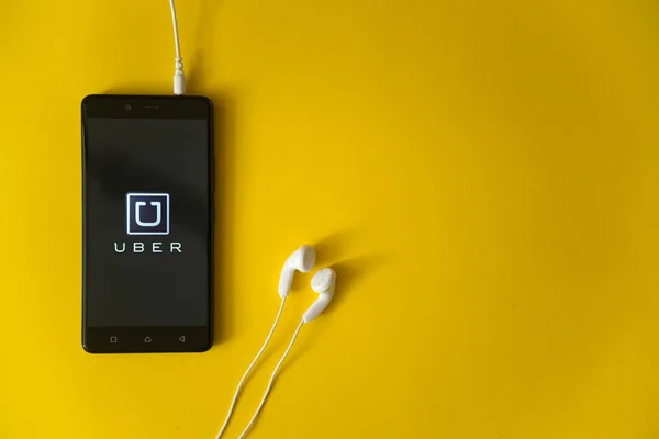 Uber-logo op het scherm van de smartphone op gele achtergrond — Stockfoto