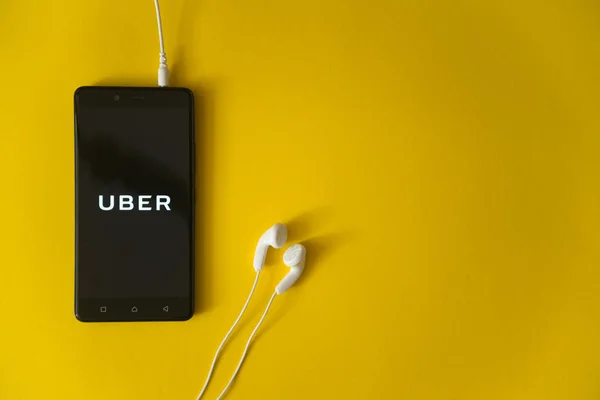 Uber-logo op het scherm van de smartphone op gele achtergrond — Stockfoto