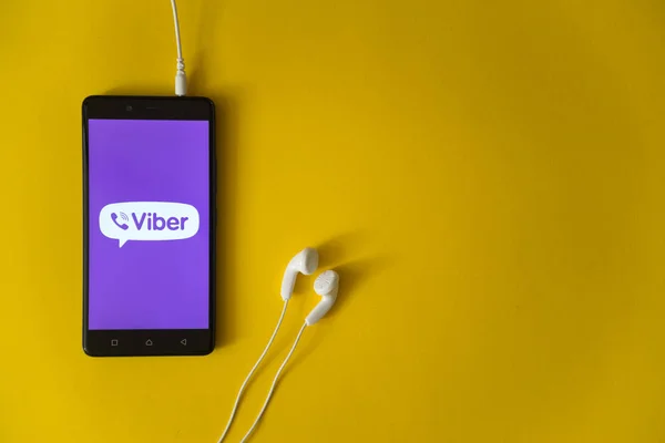 Логотип Viber на экране смартфона на желтом фоне — стоковое фото