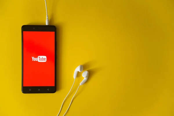 YouTube logo op het scherm van de smartphone op gele achtergrond — Stockfoto