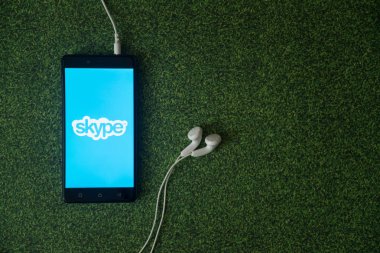 Skype logo üstünde smartphone perde yeşil çim zemin üzerine.
