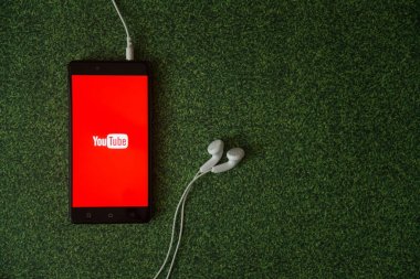 Smartphone ekran yeşil çim zemin üzerine logosuna YouTube.