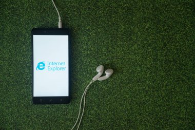 Internet explorer logo üstünde smartphone perde yeşil çim zemin üzerine.