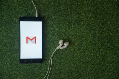 Yeşil çim zemin üzerine smartphone ekranında Gmail logosu.