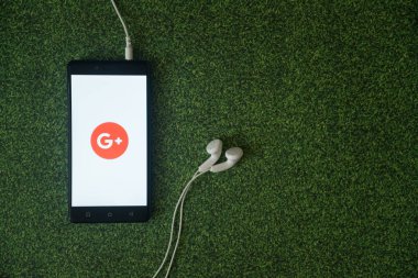 Google plus logo üstünde smartphone perde yeşil çim zemin üzerine.
