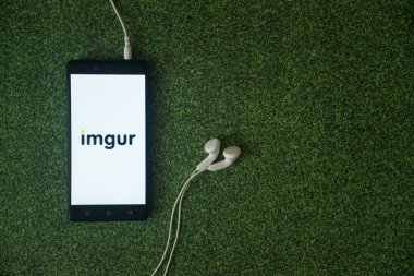 Imgur logo üstünde smartphone perde yeşil çim zemin üzerine.
