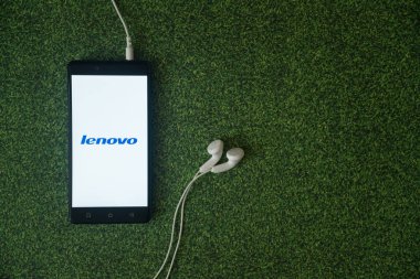 Lenovo logo üstünde smartphone perde yeşil çim zemin üzerine.
