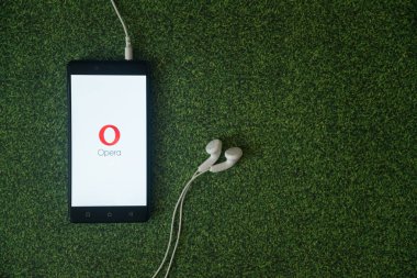 Opera mini logo üstünde smartphone perde yeşil çim zemin üzerine.