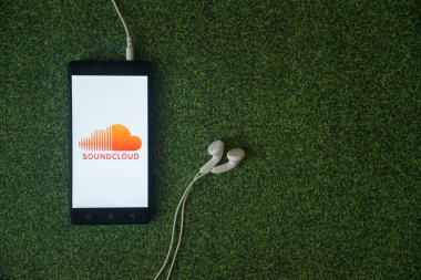 SoundCloud logo üstünde smartphone perde yeşil çim zemin üzerine.