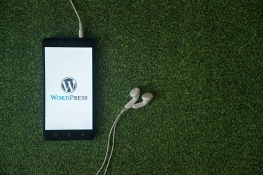 WordPress logo üstünde smartphone perde yeşil çim zemin üzerine.