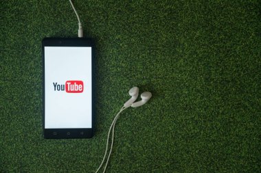Smartphone ekran yeşil çim zemin üzerine logosuna YouTube.