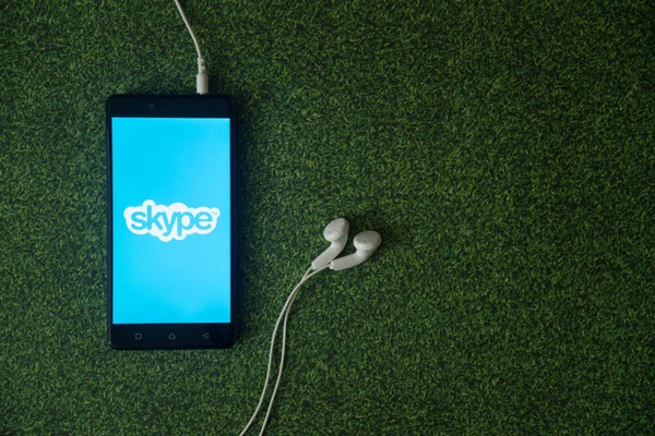 Logotipo de Skype en la pantalla del teléfono inteligente en fondo de hierba verde . — Foto de Stock