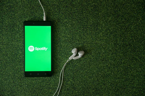 Logo üstünde smartphone perde yeşil çim zemin üzerine spotify.