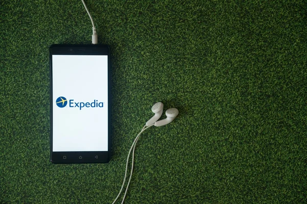 Логотип Expedia на экране смартфона на зеленом фоне . — стоковое фото