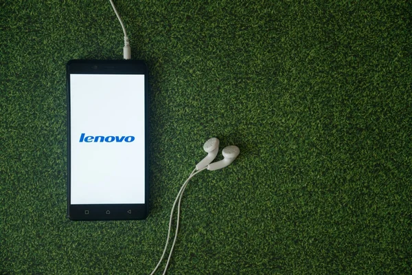 Логотип Lenovo на экране смартфона на зеленом фоне . — стоковое фото