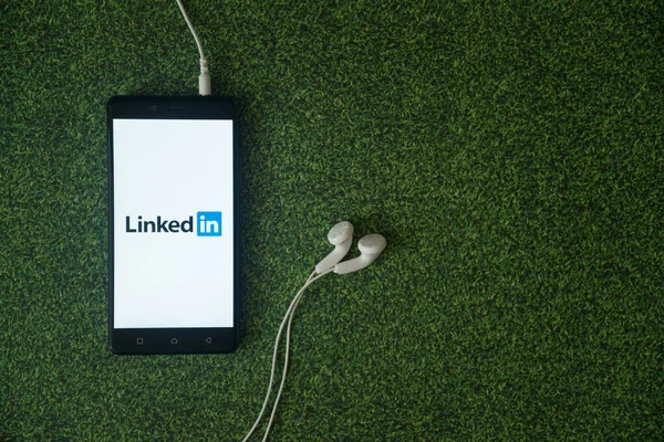 Linkedinlogo op smartphone scherm op groen gras achtergrond. — Stockfoto