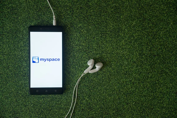 Логотип MySpace на экране смартфона на зеленом фоне травы . — стоковое фото