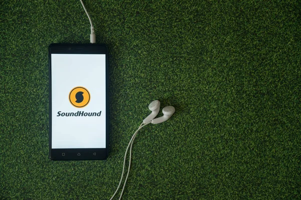 Soundcloud logo on smartphone screen on green grass background. — Stock Photo, Image