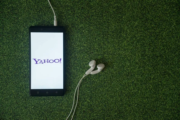 Logotipo de Yahoo en la pantalla del teléfono inteligente en fondo de hierba verde . —  Fotos de Stock