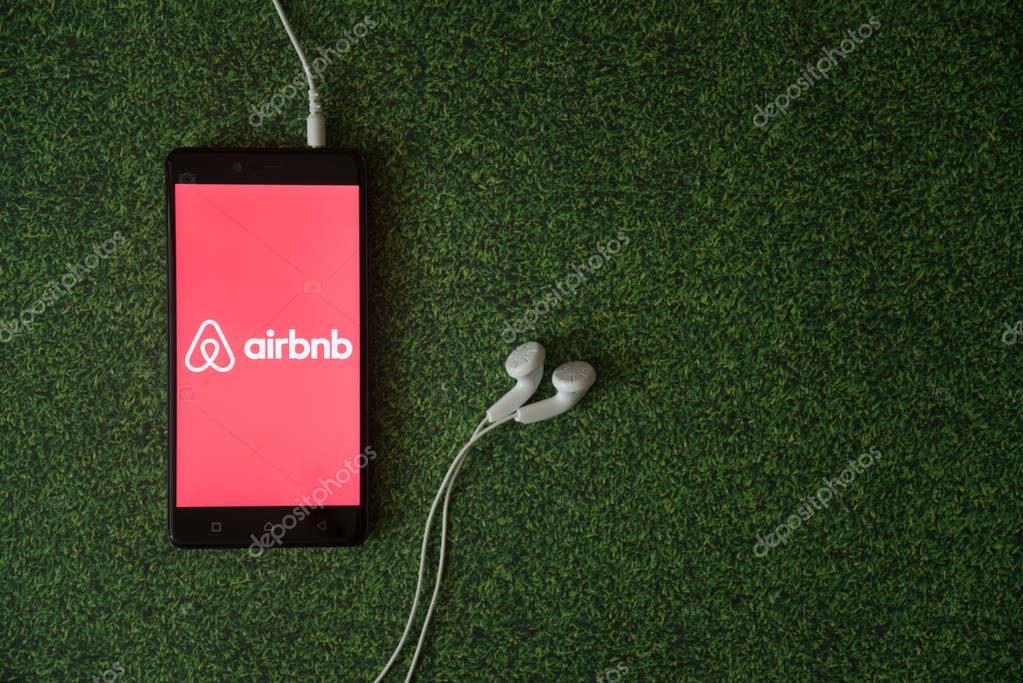 Los Angeles, USA, october 23, 2017: Airbnb logo on smartphone screen on green grass background.