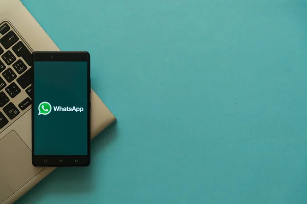 WhatsApp logo na smartphone na klávesnici notebooku. — Stock fotografie